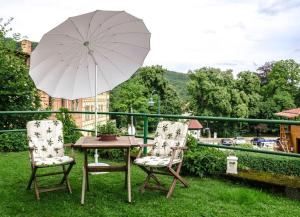 a table and two chairs with an umbrella on a balcony at Ferienwohnung Christine in Thale