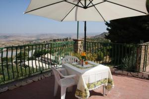 a table and chairs with an umbrella on a balcony at B&B Borgo Pileri in Mazzarino