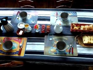 una mesa cubierta con tazas y platos de comida en Le Chêne Liège, en Maché