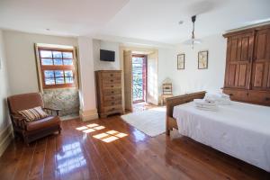 a bedroom with a large bed and a chair at Casa do Monte - Douro in Baião