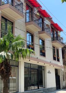 a building with a palm tree in front of it at Gala Boutique Hotel in Kutaisi