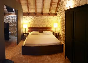 ein Schlafzimmer mit einem Bett und zwei Tischen mit Lampen in der Unterkunft La Grange du Moulin in Noyers-sur-Cher