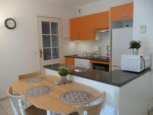 a kitchen with a wooden table with chairs and a microwave at Eric's Appartement -Charmant T2 - in Cambo-les-Bains