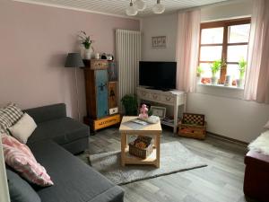 ein Wohnzimmer mit einem Sofa und einem TV in der Unterkunft Ferienwohnung Sambachhaus in Gleiszellen-Gleishorbach