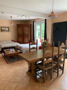 a living room with a table and a bed at Villa Toulousaine in Grisolles