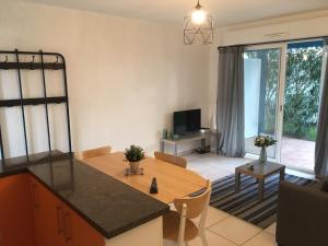 una cucina e un soggiorno con tavolo e TV di Eric's Appartement -Charmant T2 - a Cambo-les-Bains