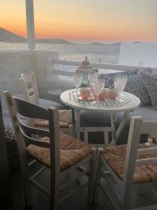 Una mesa y sillas en un balcón con vista al mar. en Asimi House, en Naousa 27 fotos más