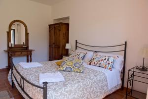 Dormitorio con cama con espejo y tocador en Agriturismo Le Folaghe en Terracina
