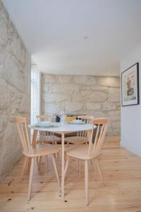 een eetkamer met een witte tafel en stoelen bij Liiiving in Porto - Charming Downtown Delight in Porto