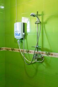 baño verde con ducha con pared verde en Olina Hotel and Apartments Kampala, en Kampala