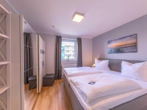 sypialnia z dużym łóżkiem i oknem w obiekcie Modernes Apartment "Stadtblick" w mieście Waren