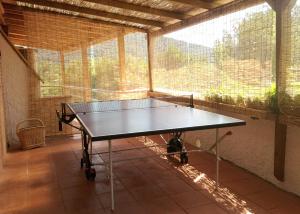 tavolo da ping pong in una stanza con finestra di Hotel Paradiso a Portoferraio