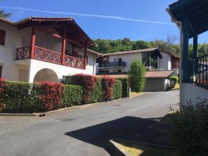 una casa con una siepe di fronte a una strada di Eric's Appartement -Charmant T2 - a Cambo-les-Bains