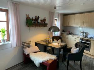 eine Küche mit einem Tisch und Stühlen sowie ein Esszimmer in der Unterkunft Ferienwohnung Sambachhaus in Gleiszellen-Gleishorbach