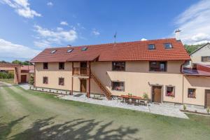 a large house with a red roof and a yard at Apartmány Pod Řípem in Roudnice nad Labem