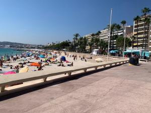 a group of people on a beach with the ocean at 3P luxe proche Croisette in Cannes