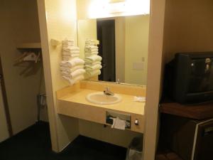 a bathroom with a sink and a mirror at Starlite Budget Inn in Mackinaw City +24 photos