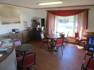 a waiting room with tables and chairs and a window at Starlite Budget Inn in Mackinaw City