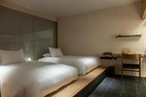 Un pat sau paturi într-o cameră la modern ryokan kishi-ke