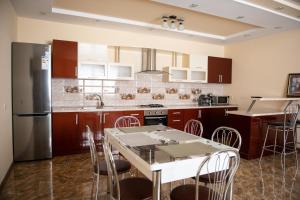 a kitchen with a table with chairs and a refrigerator at Затишна оселя in Mizhhirya