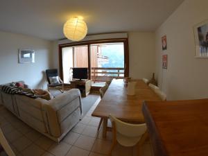 a living room with a couch and a table at VAUJANYLOCATIONS- Chalet du Verney in Vaujany