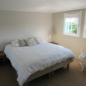 a bedroom with a large white bed with a window at Résidence les Grimaudières in Grimaud +63 photos