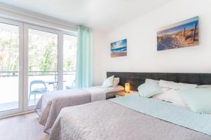 a bedroom with two beds and a balcony at ORKA in Pobierowo