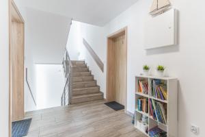 een trap in een huis met witte muren en houten vloeren bij ORKA in Pobierowo