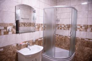 ein Bad mit einer Dusche und einem Waschbecken in der Unterkunft Затишна оселя in Mischhirja