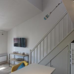 a staircase in a living room with a couch and a table at Résidence les Grimaudières in Grimaud
