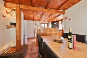 a kitchen with a table with a bottle of wine at Le Chalet du Tanet spa sauna terrasse en Alsace in Soultzeren