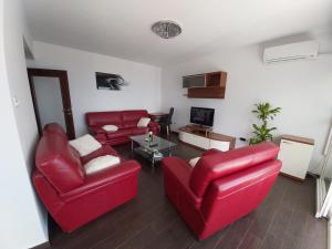 ein Wohnzimmer mit zwei roten Sofas und einem Tisch in der Unterkunft Apartment Alina, Kastav in Kastav