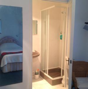a bathroom with a shower and a bedroom with a bed at The Clan MacGregor Room in Kilmarnock