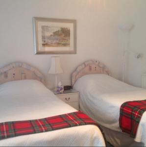 1 dormitorio con 2 camas y una foto en la pared en The Clan MacGregor Room, en Kilmarnock