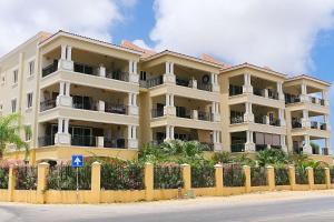 a large yellow building with a fence in front of it at BonaireChoice Apartment in Kralendijk