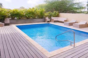 a swimming pool on a deck next to a house at BonaireChoice Apartment in Kralendijk