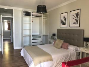 - une chambre avec un grand lit et des draps blancs dans l'établissement Flores & Campos Guest House, à Santa Cruz de Tenerife