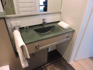ein Bad mit einem Waschbecken und einem Spiegel in der Unterkunft Apart-Hotel Wiesbaden in Wiesbaden