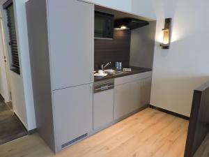 eine kleine Küche mit einer Spüle und einer Mikrowelle in der Unterkunft Apart-Hotel Wiesbaden in Wiesbaden