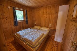 a bedroom with a bed in a wooden room at Vrådal Hyttegrend in Vradal