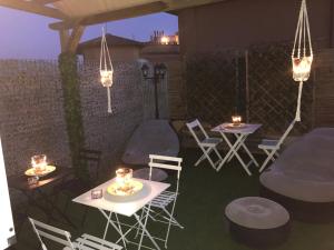 un patio con 2 mesas, sillas y luces en B&B Da Ponticello, en Roma