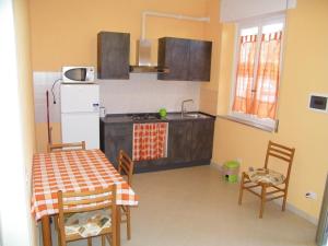 een keuken met een tafel en stoelen en een koelkast bij Home89 in Lucca