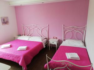2 Betten in einem Zimmer mit rosa Wänden in der Unterkunft Diva Star Bol in Bol