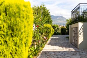 un camino en un jardín con plantas amarillas en Hotel Aphrodite en Stoúpa