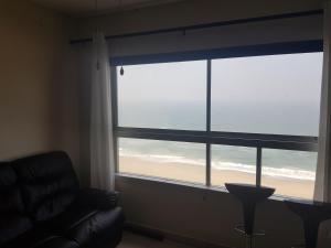 a living room with a window with a view of the beach at Pam's Beach Flat in Amanzimtoti