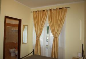 a bathroom with a shower curtain and a toilet at Il Boschetto in Porto SantʼElpidio