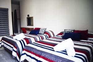 a group of three beds in a room at En el Centro 1 Hermoso Lof't Familiar AC WiFi 300 mbps in Aguascalientes