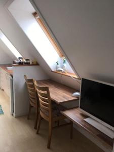 a dining room with a table with a computer on it at Ro i skoven - men tæt på byen in Varde