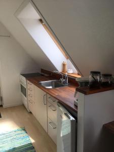 a kitchen with a sink and a counter top at Ro i skoven - men tæt på byen in Varde