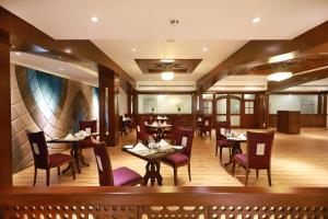 a restaurant with tables and chairs in a room at Islamabad Regalia Hotel in Islamabad